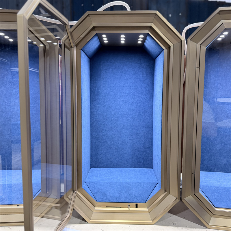 Detail of an open octagonal jewelry display case with a hinged glass door and illuminated blue suede interior